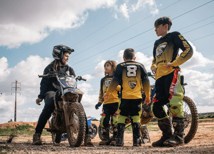 Bruna Antunes with a group of kids at the motocross school
