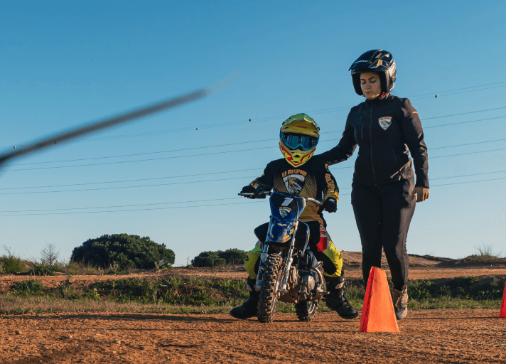 Bruna Antunes with young riders wearing full protective gear for motocross lessons