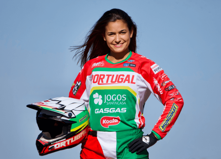 Female national motocross champion of Portugal holding the portuguese flag